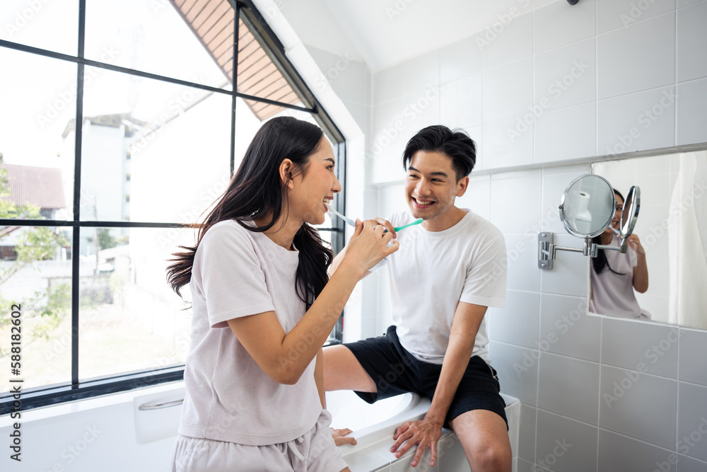 Asian new marriage couple brushing teeth together in bathroom at home. 