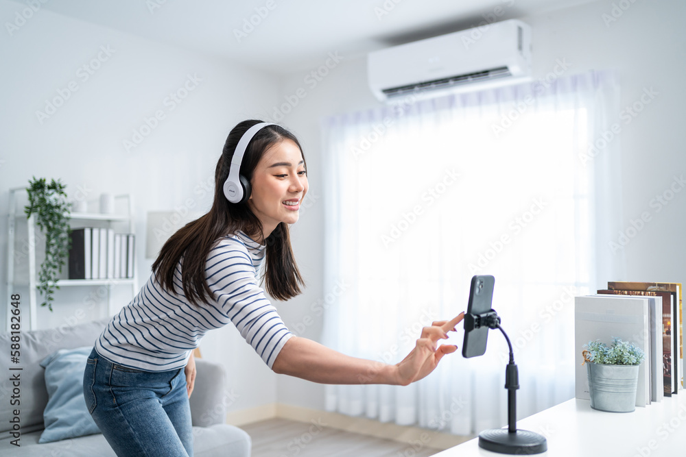 Asian attractive woman enjoy dance with music in living room at home. 