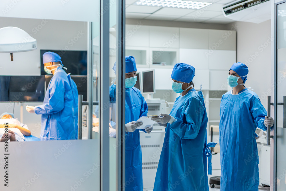 Professional doctors performing surgical operation in operating room.