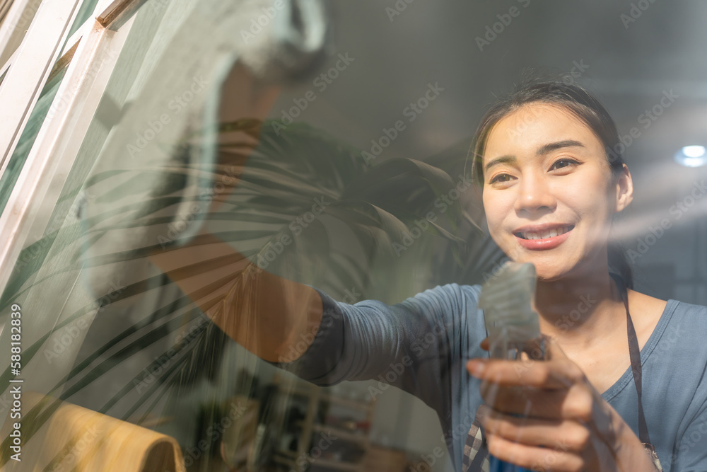 Asian cleaning service woman worker cleaning in living room at home.