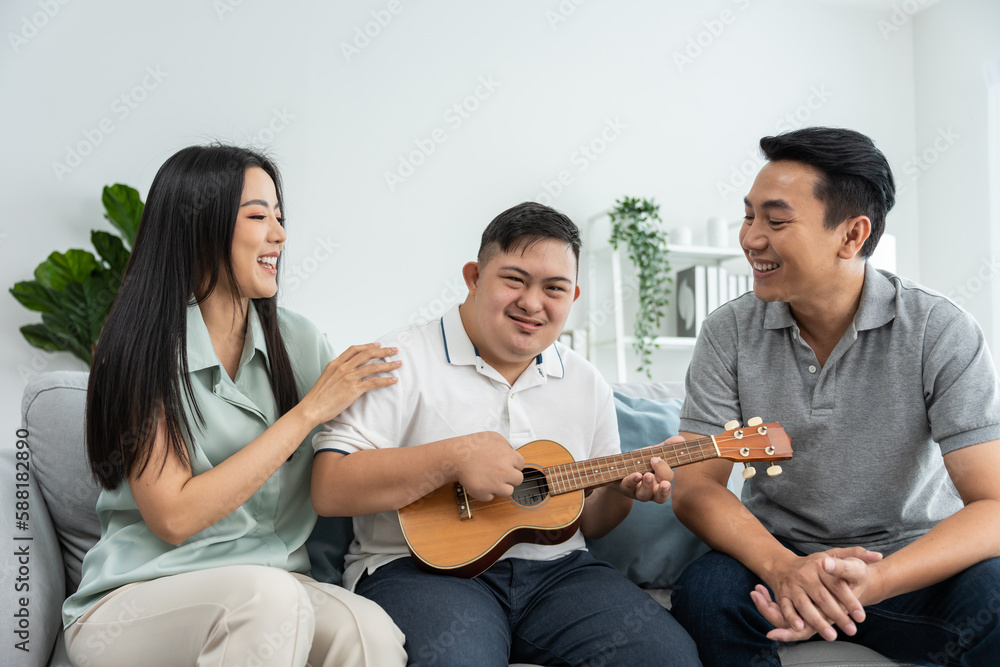 Asian attractive family playing with young son in living room in house. 