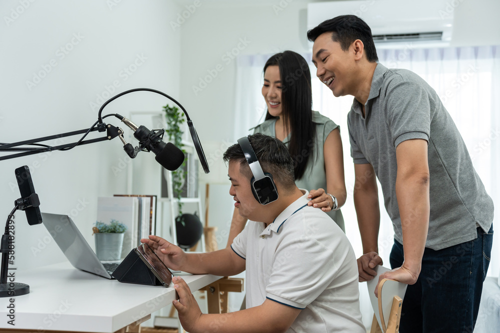 Asian young DJ man speaking on microphone at studio with loving parent. 