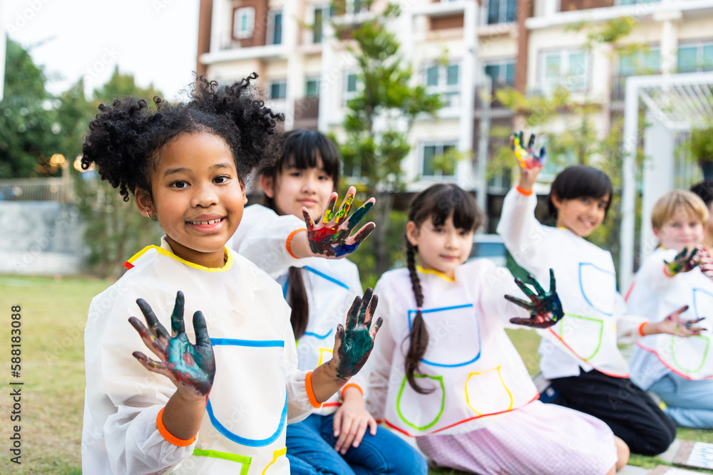 Group of student coloring on painting board outdoors in school garden. 