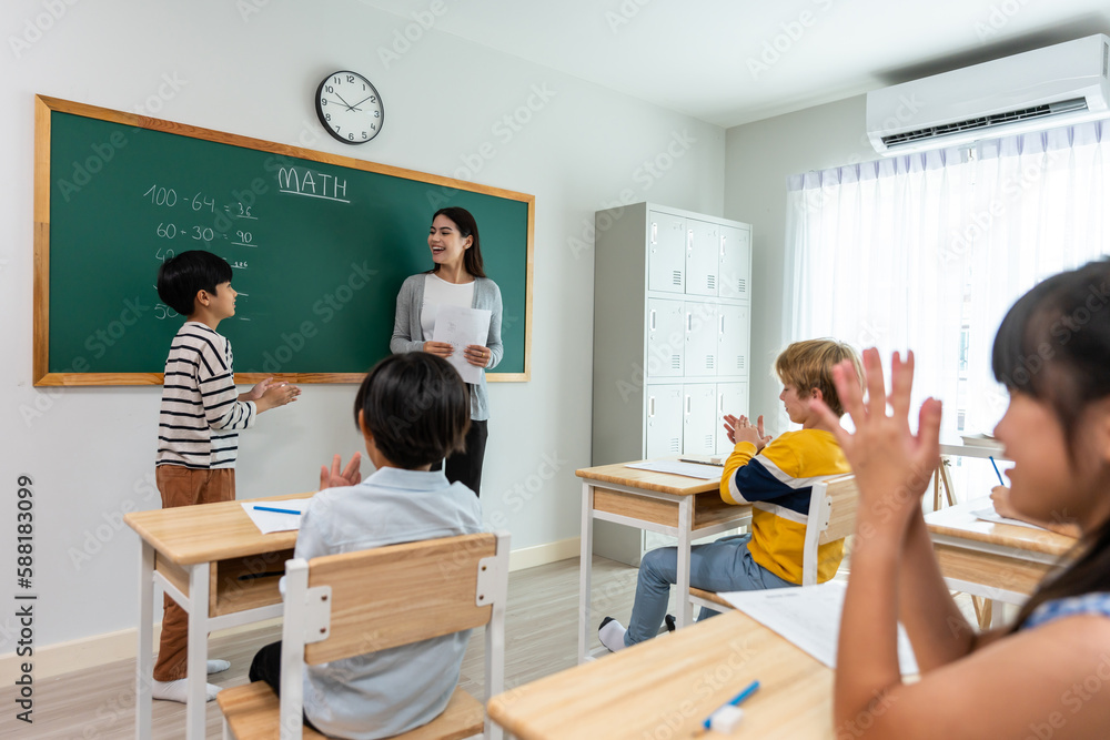 Group of student learn with teacher in classroom at elementary school. 