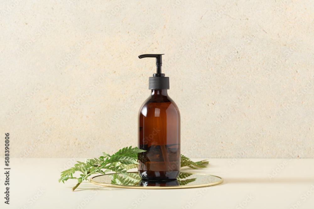 Pump amber glass bottle on beige background. Soap liquid, shampoo or shower gel packaging design