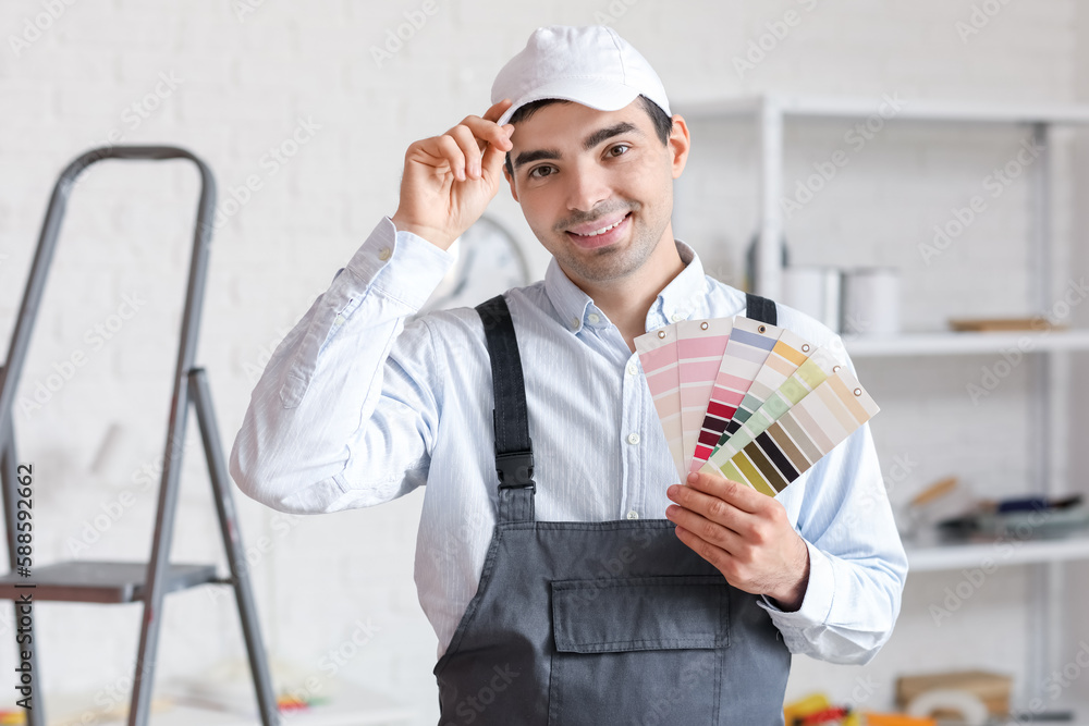 Male painter with color palettes in room