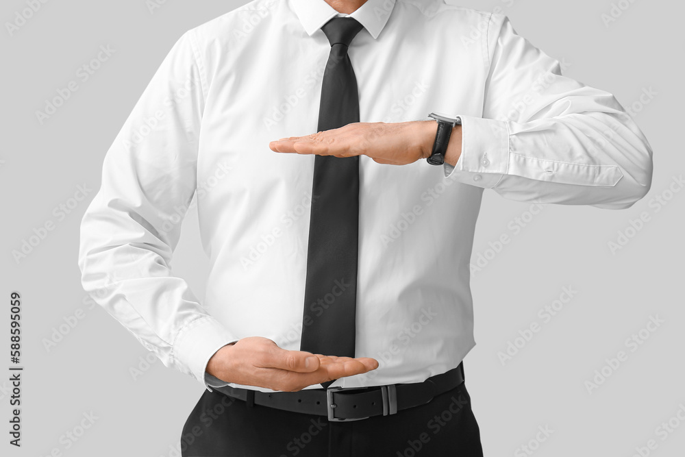 Mature business consultant holding something on light background, closeup