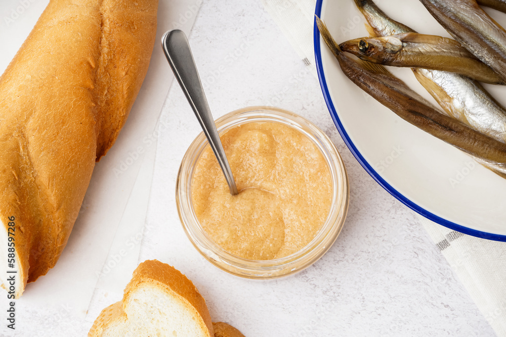 Jar with delicious caviar of capelin, baguette and smoked fish on white background