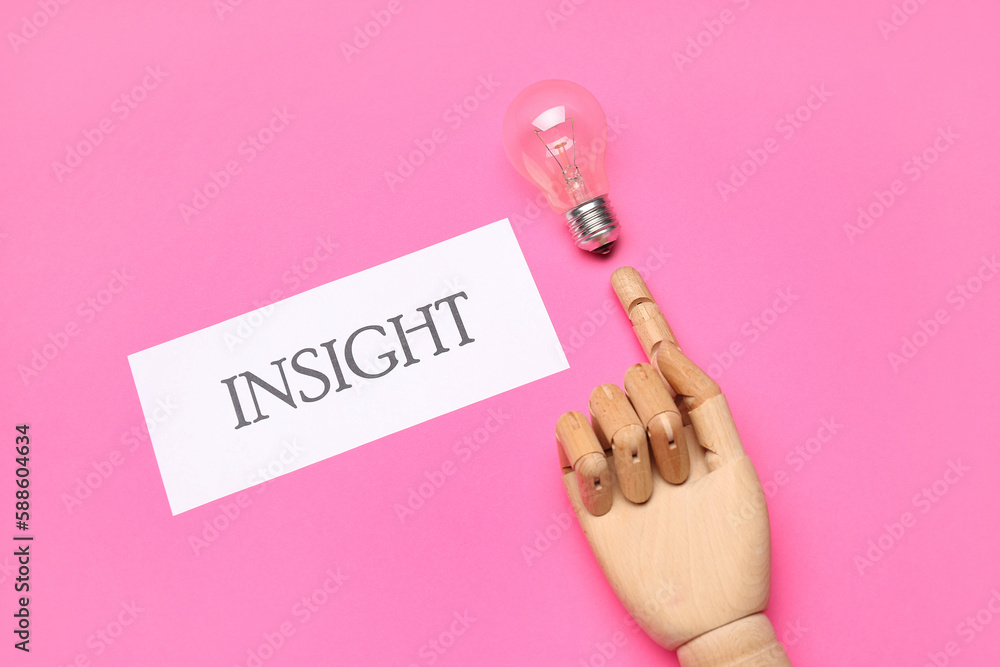 Paper with word INSIGHT, wooden hand and light bulb on pink background