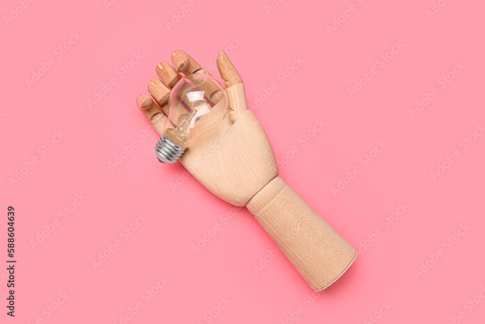 Wooden hand with light bulb on pink background. Insight concept