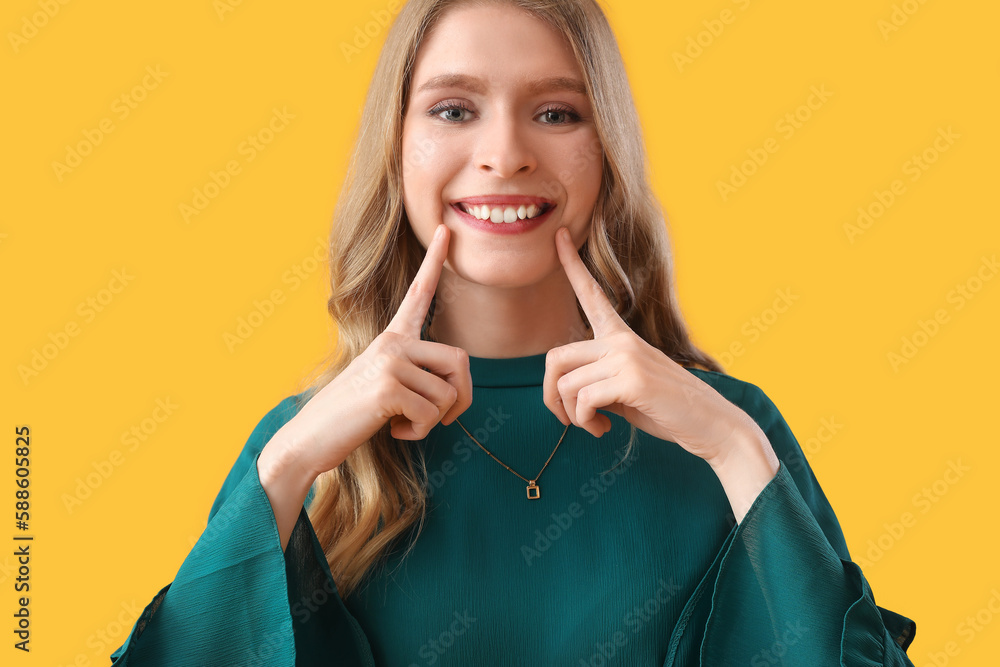 Young woman smiling on yellow background, closeup