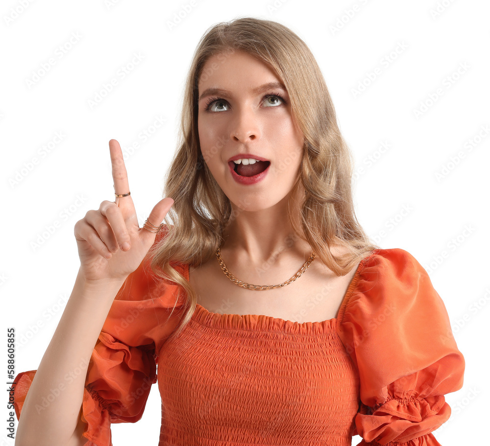 Surprised young woman pointing at something on white background