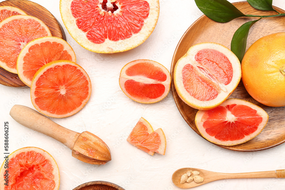 Composition with cut ripe grapefruits on light background