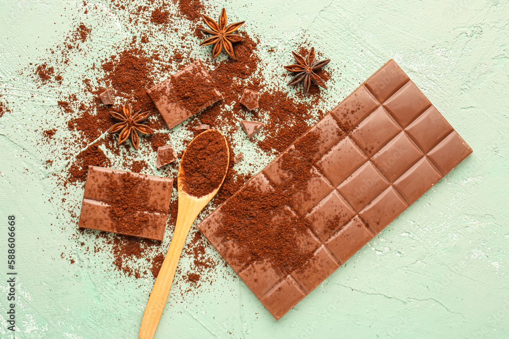 Composition with tasty chocolate, coffee powder and anise stars on green background