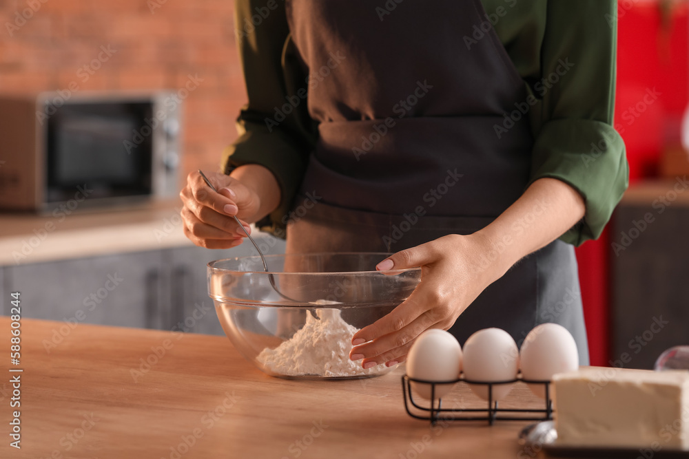 Woman making dough for pasta at table in kitchen, closeup