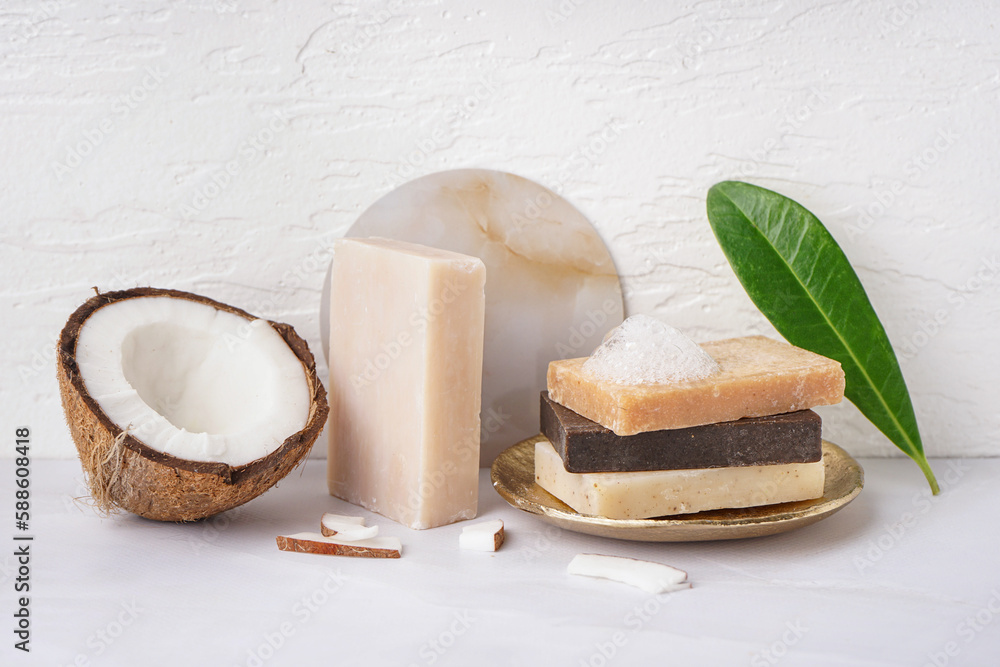 Plate with natural soap bars and coconut on light table