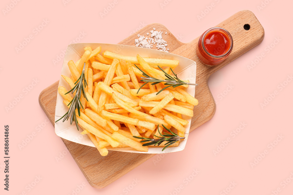 Paper box with tasty french fries, ketchup and salt on pink background