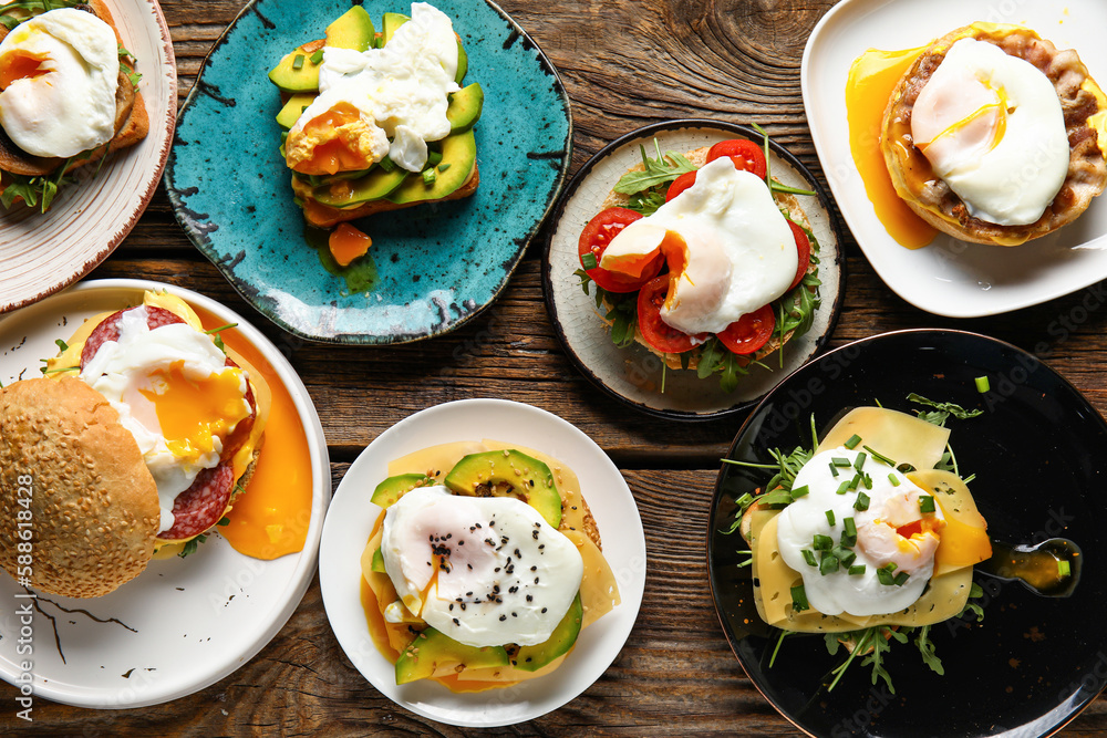 Plates with tasty eggs Benedict on wooden background