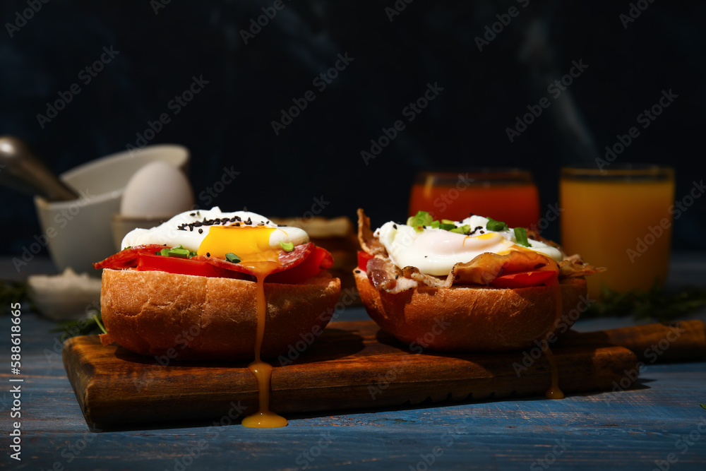 Board with tasty eggs Benedict on table