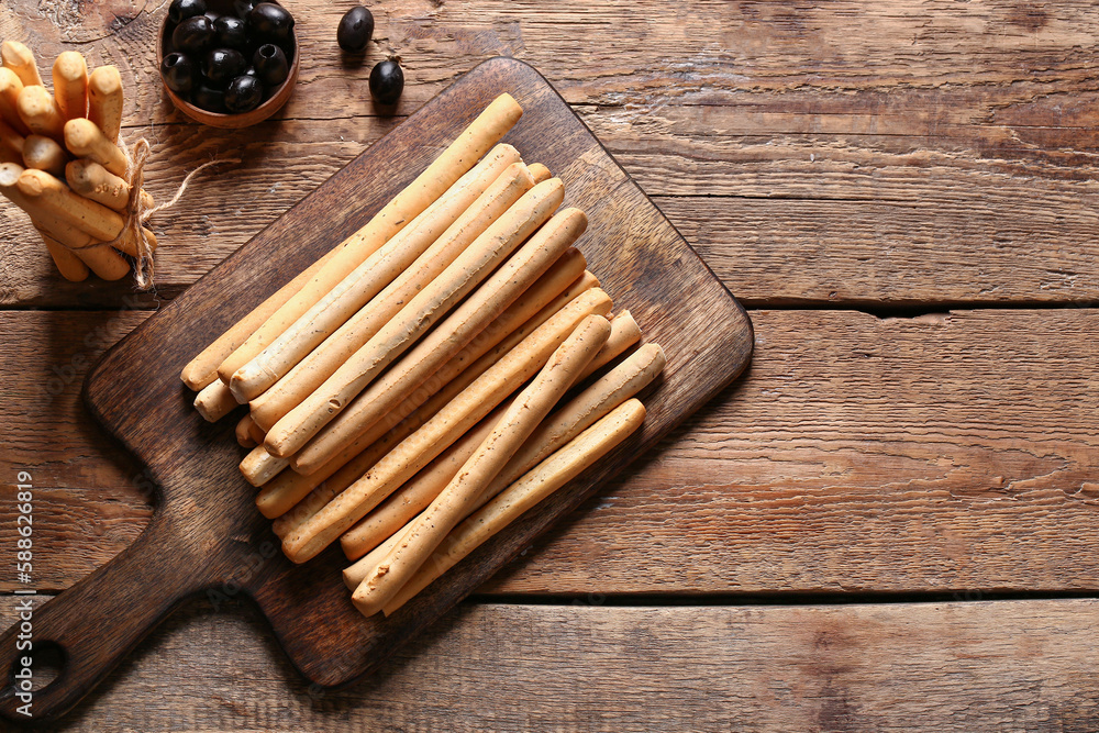 Board with tasty Italian Grissini on wooden background