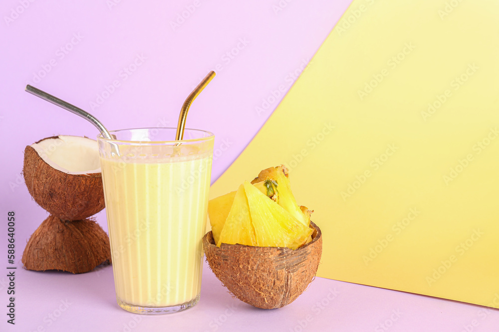 Glass of tasty pineapple smoothie, straws and coconut on color background