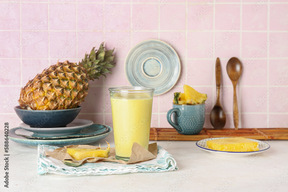 Glass of tasty pineapple smoothie on table in kitchen