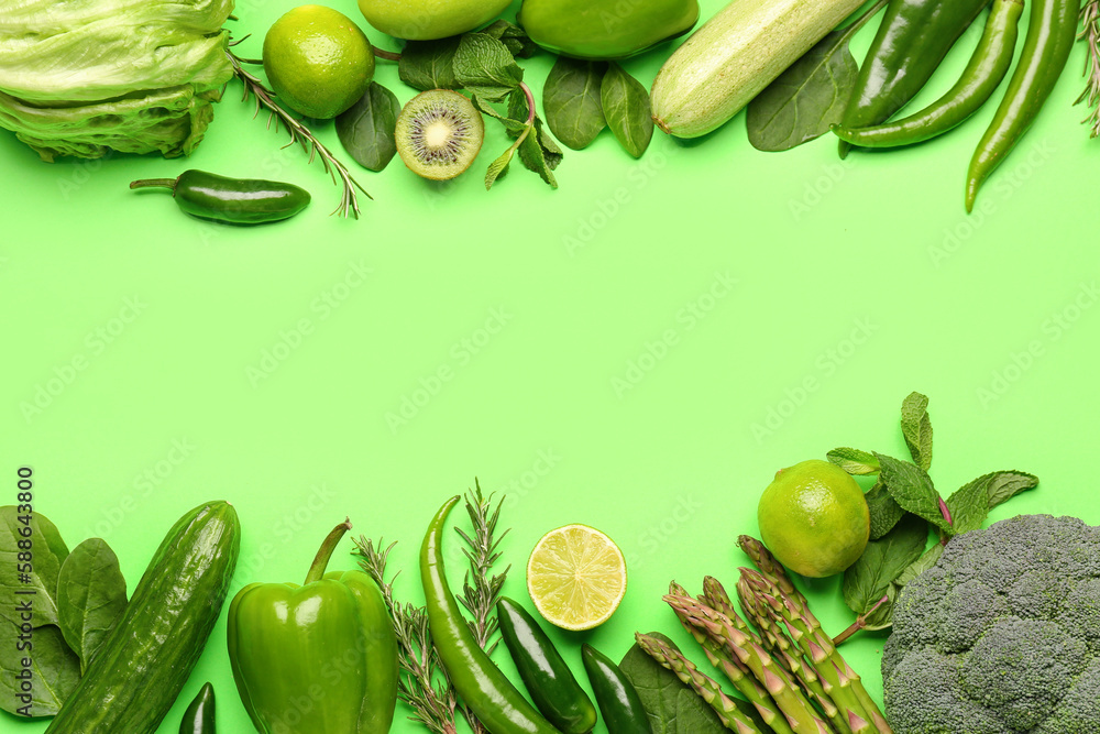 Frame made of different fresh vegetables and fruits on green background