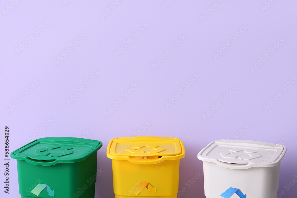 Containers for garbage on lilac background. Recycling concept