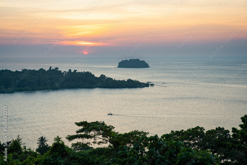 View over the calm waters of the sea wit the pink sunset in the background