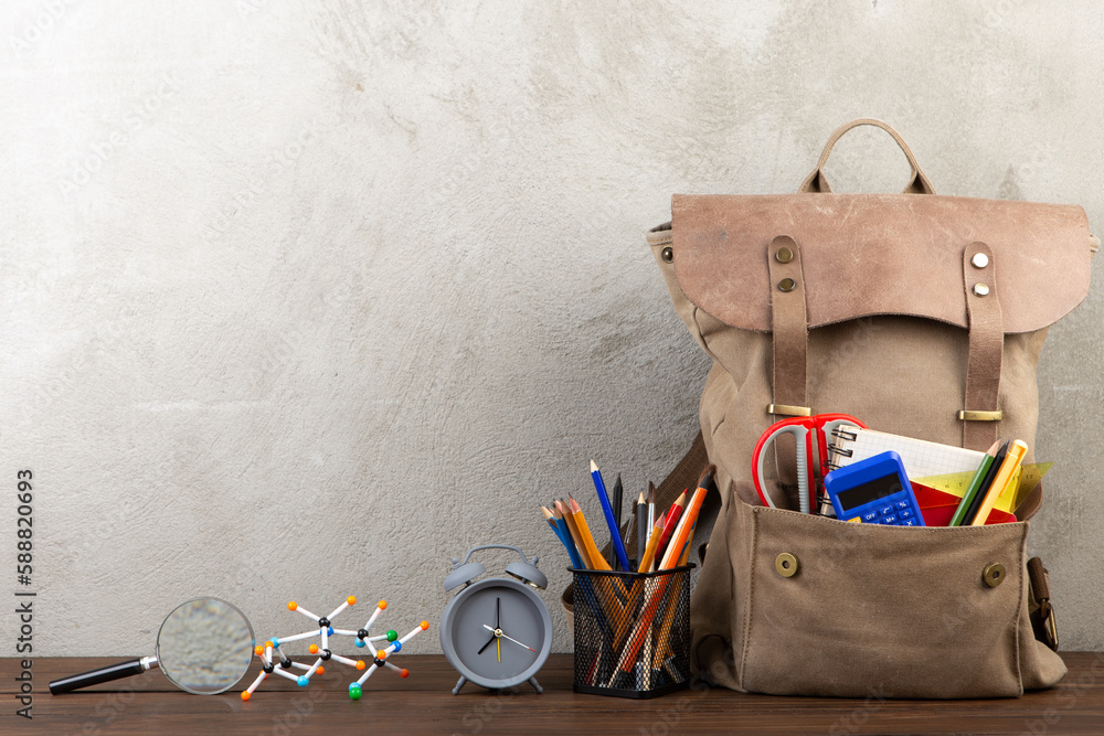 Back to school - books and school backpack on the desk in the auditorium, Education concept.