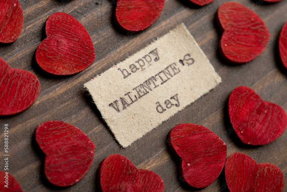 Happy Valentine`s day - typed text. Valentines Day greetings concept. Little red wooden hearts close