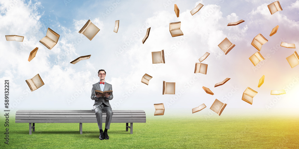 Young businessman or student studying the science and books fly around