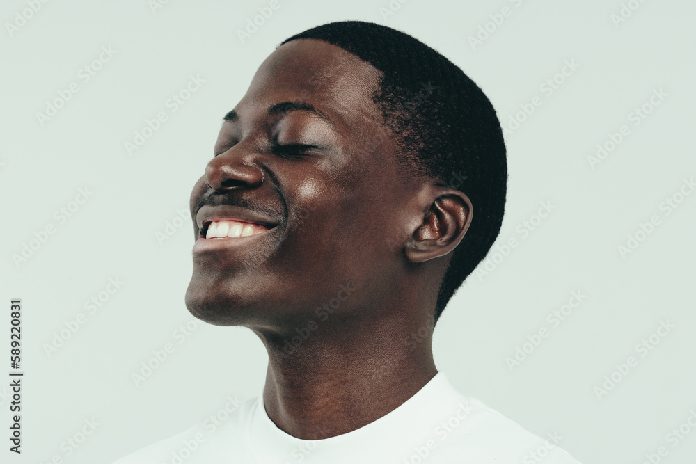 Black man celebrating his beautiful, flawless melanin skin in a studio