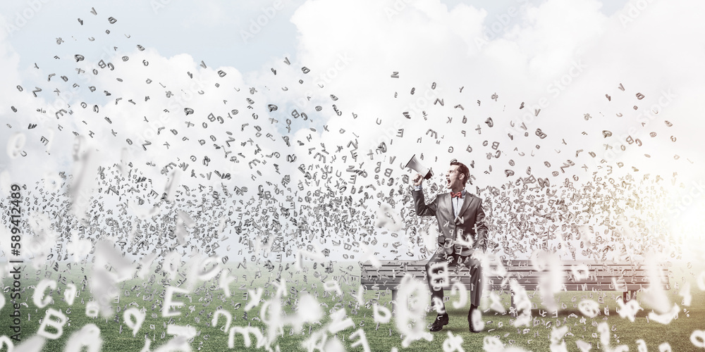 Businessman in summer park announcing something in loudspeaker and symbols fly around