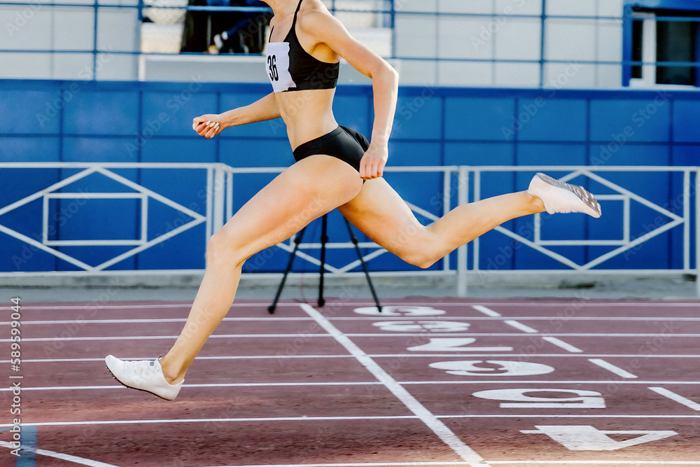 female leader runner crosses finish line on stadium track, sprint race in athletics competition