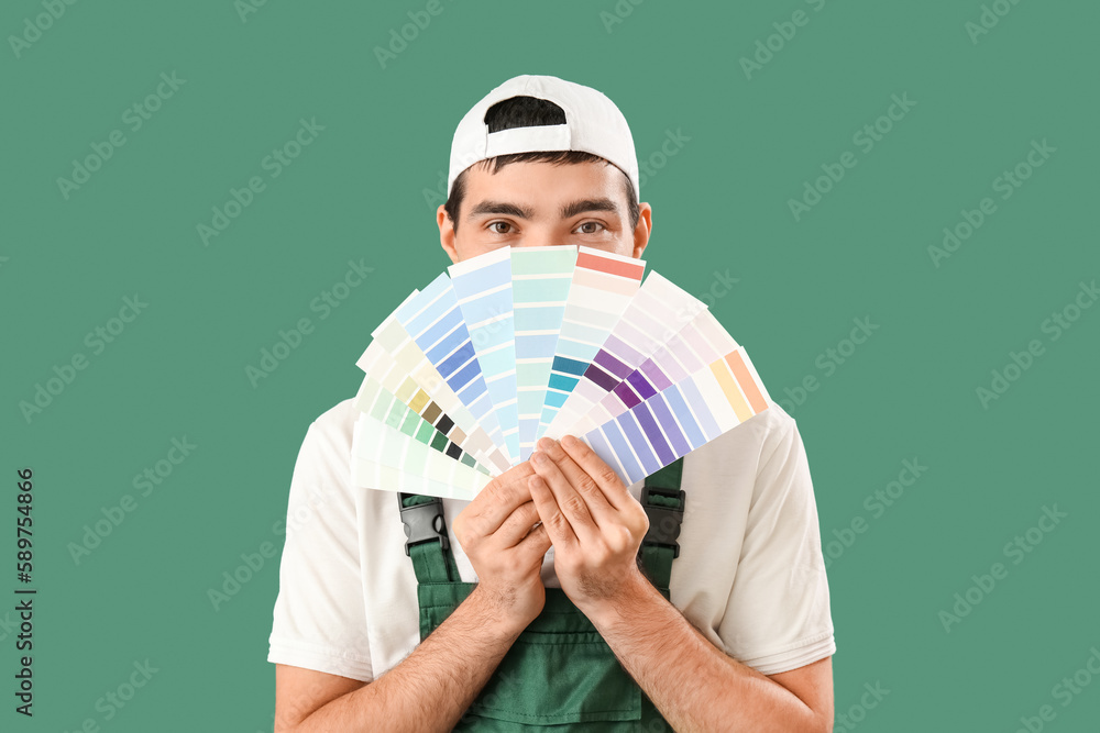 Male painter with color palettes on green background