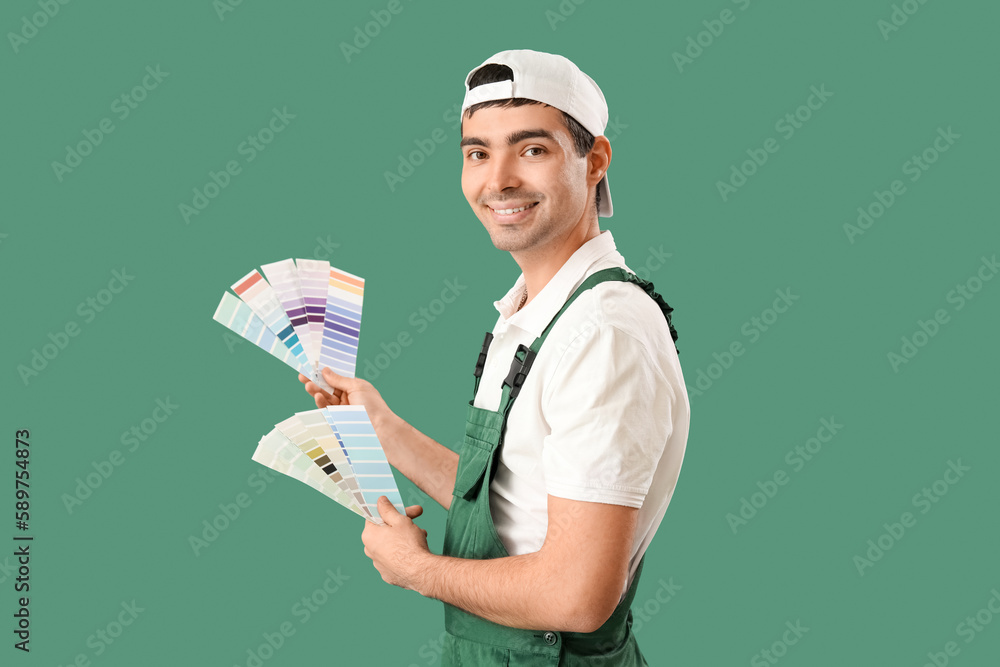 Male painter with color palettes on green background