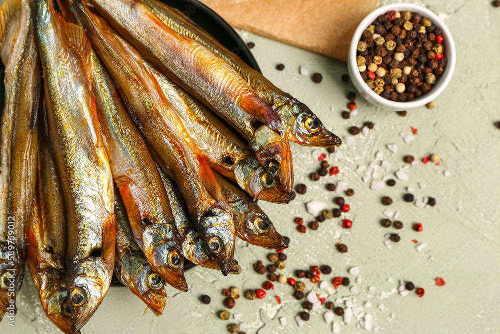 Tasty smoked capelin on grey background, closeup