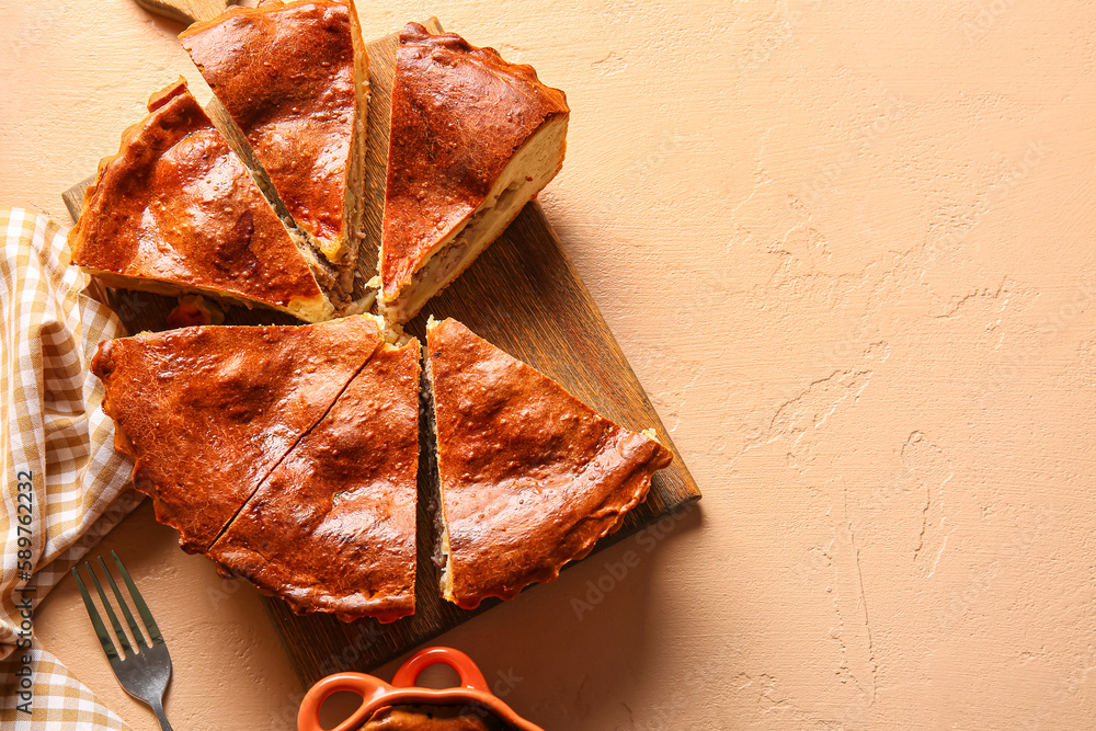 Board with pieces of delicious meat pie on beige table