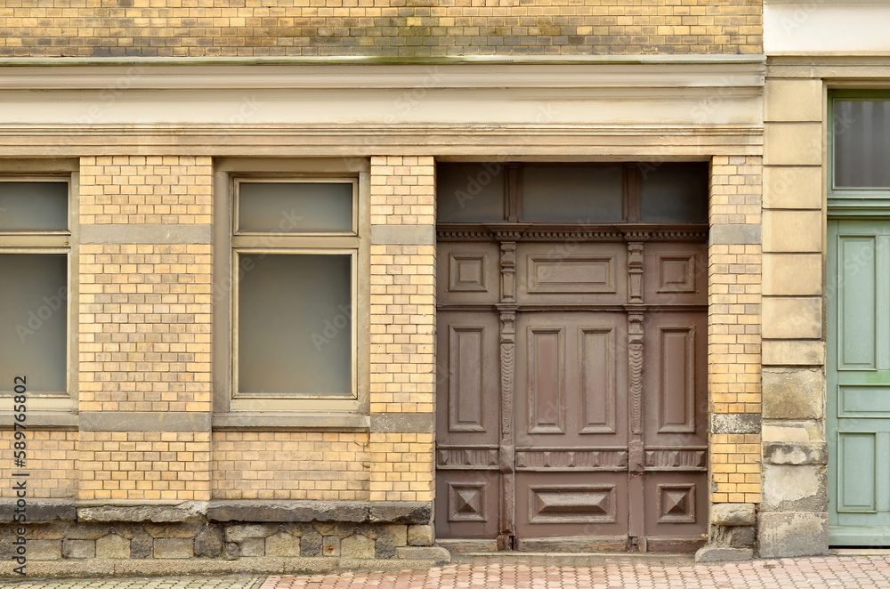 View of brick building with wooden door and windows