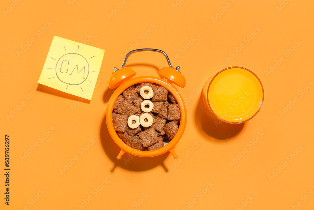 Alarm clock with corn pillows and glass of juice on color background