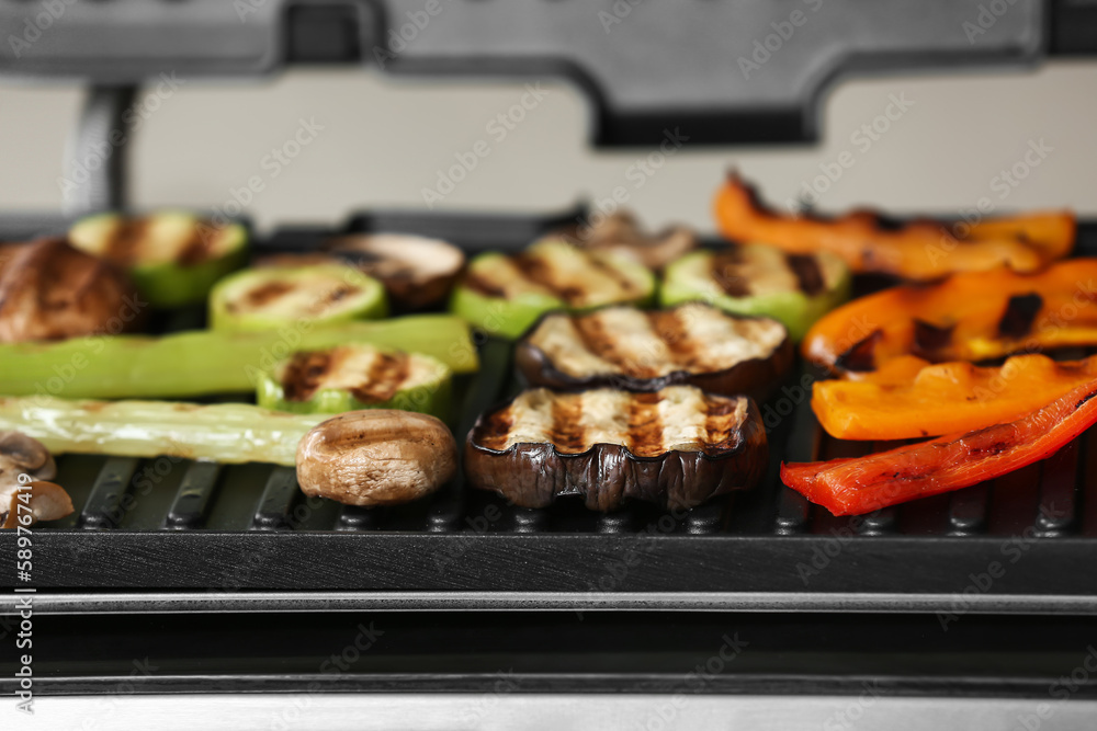 Tasty vegetables on modern electric grill, closeup