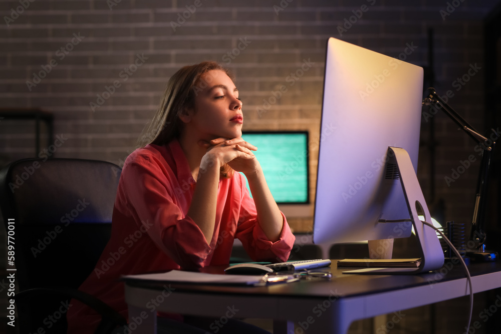 Tired female programmer working in office at night