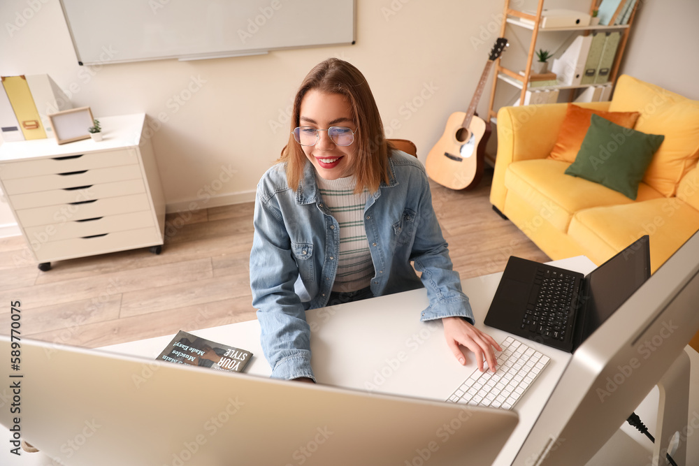 Female programmer working with computer at table in office