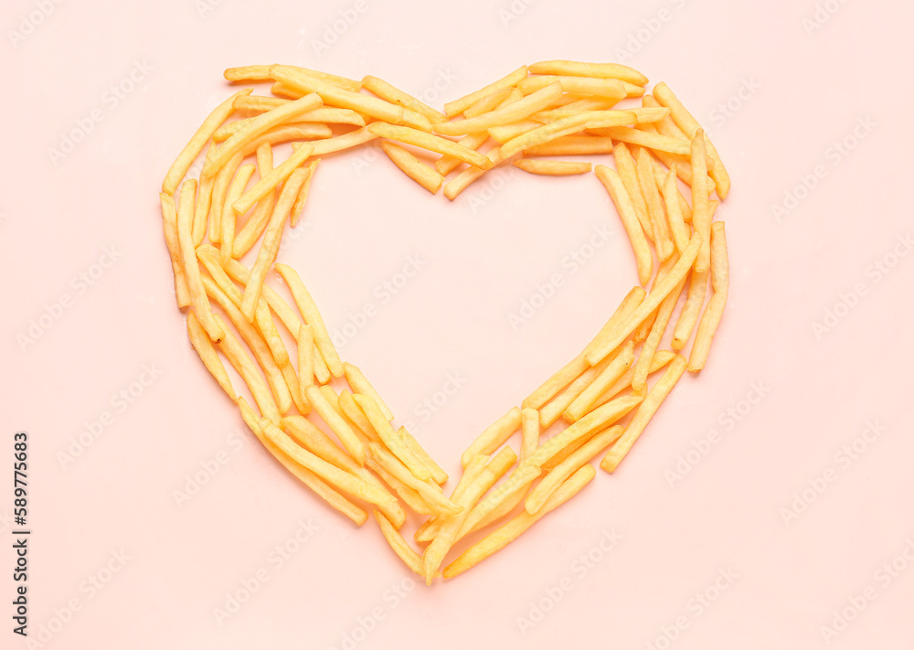 Heart made of tasty french fries on pink background