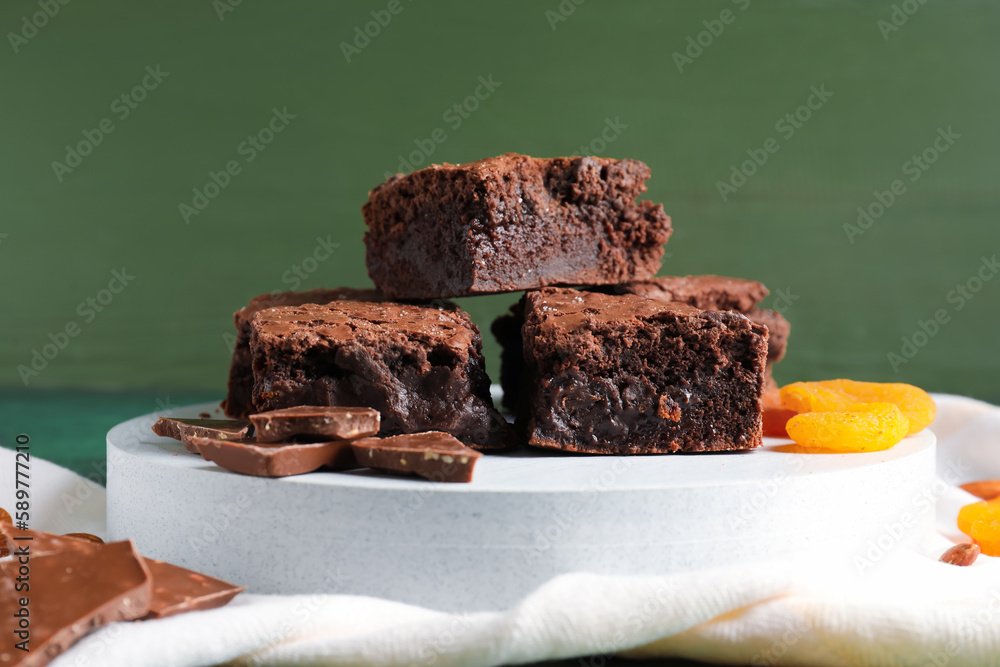 Board with pieces of tasty chocolate brownie on table