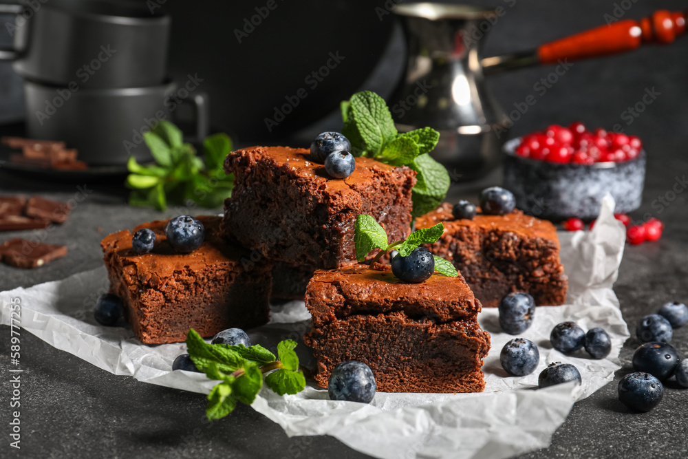 Pieces of tasty chocolate brownie on black background