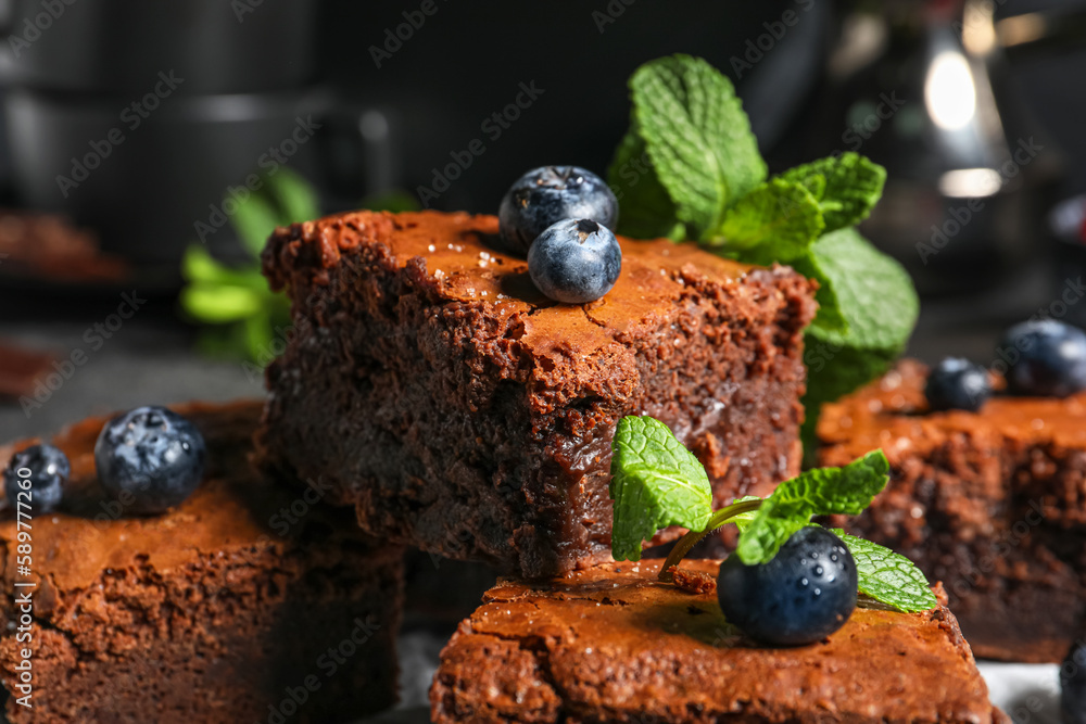 Pieces of tasty chocolate brownie on black background, closeup