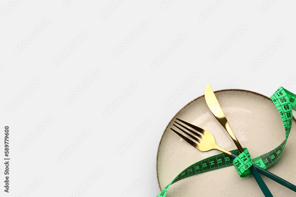 Table setting with measuring tape on light background