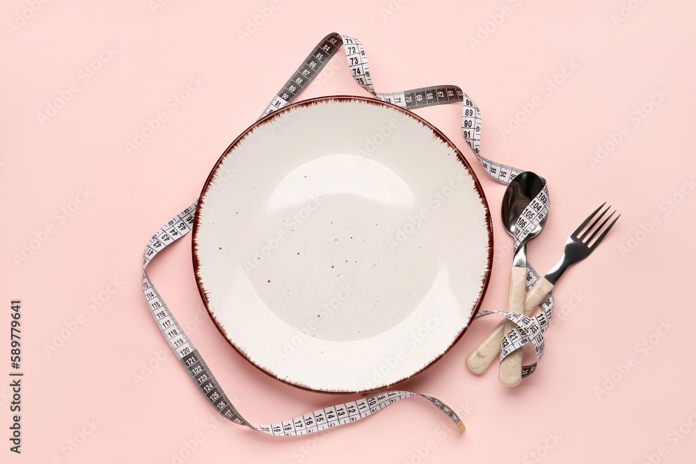 Table setting with measuring tape on pink background